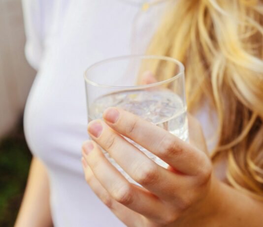 무더위 속 건강 지키기, 여름철 생활 관리법 a woman holding a glass of water in her hand