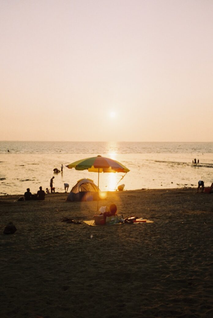 a beach with people and umbrellas