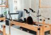 필라테스, 일상 속 건강 트렌드로 자리잡다…바쁜 현대인을 위한 실천법은? a woman is doing exercises on a rowing machine