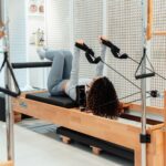 필라테스, 일상 속 건강 트렌드로 자리잡다…바쁜 현대인을 위한 실천법은? a woman is doing exercises on a rowing machine