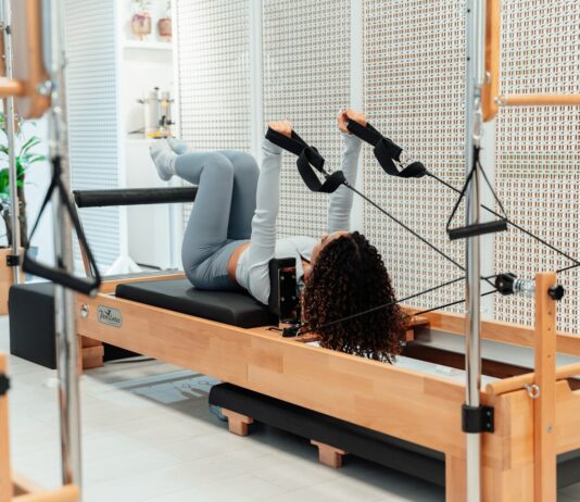 필라테스, 일상 속 건강 트렌드로 자리잡다…바쁜 현대인을 위한 실천법은? a woman is doing exercises on a rowing machine