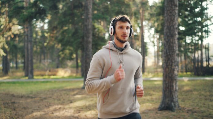 Man with headphones running in a forest
