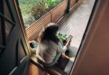 만성피로, 작은 습관 변화로 극복… 한국 일상을 위한 실천 전략 Woman sitting on balcony with smartphone