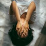 일상 속 스트레스, 새로운 관리법이 뜬다…실천 가능한 루틴은? a woman holds her hands over her face