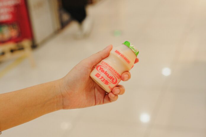 Hand holding a bottle of yakult