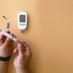 ‘혈당 스파이크’ 막는 실천법: 생활 속 작은 변화로 큰 건강 지키기 a person holding a thermometer next to an electronic device